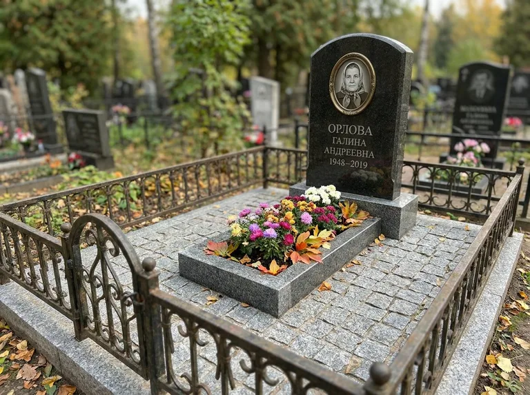 Благоустроенное захоронение с гранитной плиткой, оградой и цветником в Якутске