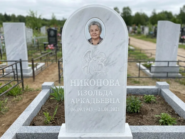 Памятник с гравировкой ангела — белая гравировка скорбящего ангела над портретом, работа «Гордеева» в Якутске