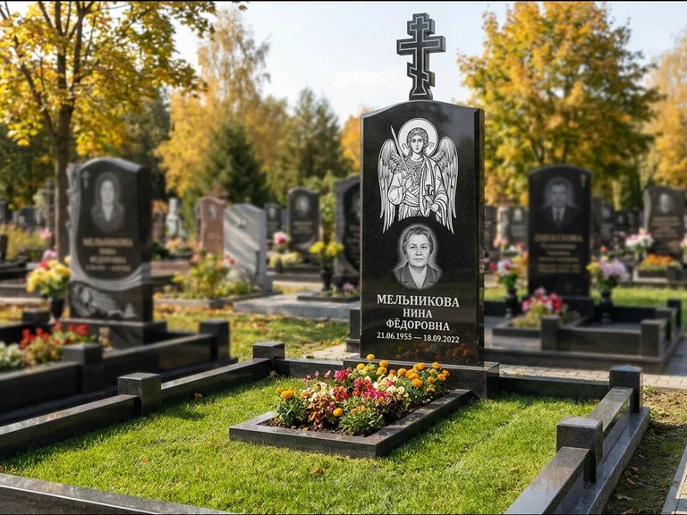 Памятник с гравировкой иконы: округлая стела-медальон с ликом — гравировка Богородицы «Семистрельная», луговые травы и полевые цветы за участком, работа «Гущин» в Якутске