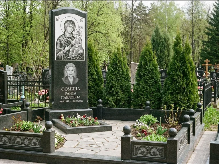 Памятник с гравировкой иконы: высокий гранёный обелиск с крестом-навершием — гравировка образа Матроны Московской, открытый участок без ограды, работа «Третьяков» в Якутске
