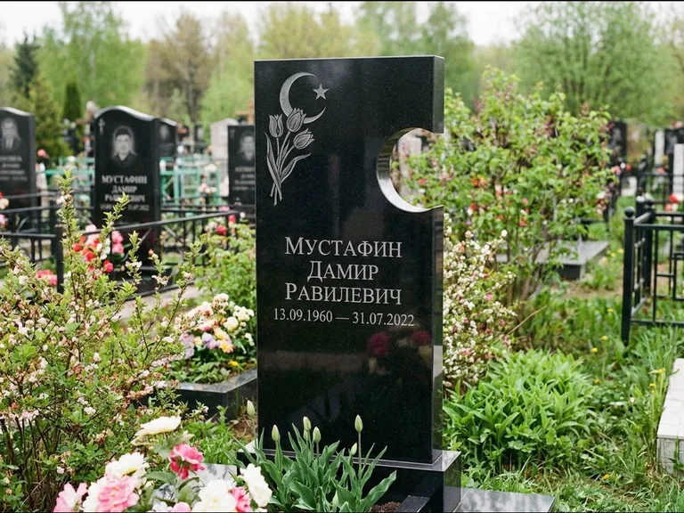 Мусульманский памятник: стела с боковым вырезом в форме полумесяца — гравировка минарета с полумесяцем, низкие кусты в цвету, работа «Мустафин» в Якутске