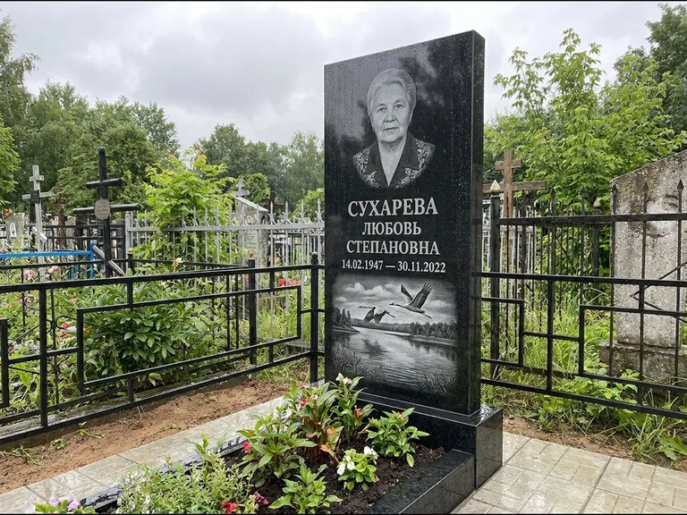 Памятник с гравировкой журавлей — гравировка пары журавлей над гладью озера в нижней части, работа «Сухарева» в Якутске