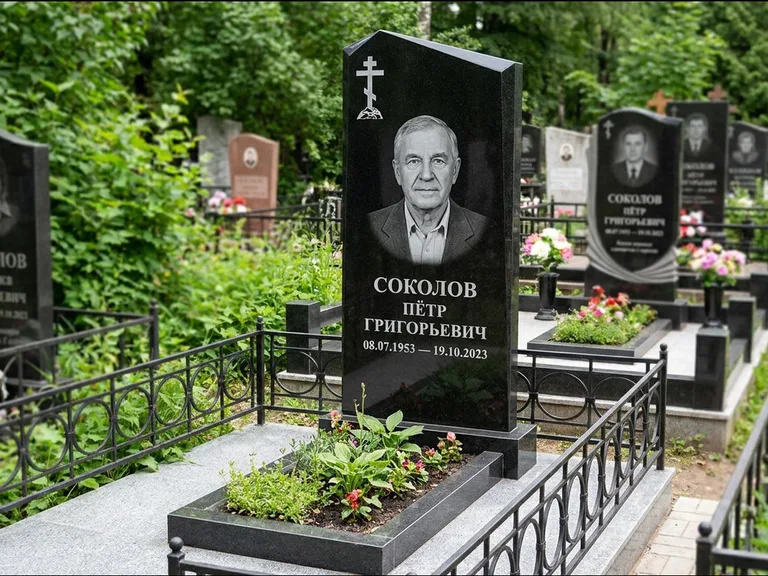 Памятник из чёрного гранита — полукруглая стела с крестом на Голгофе, работа «Журавлёв» в Якутске