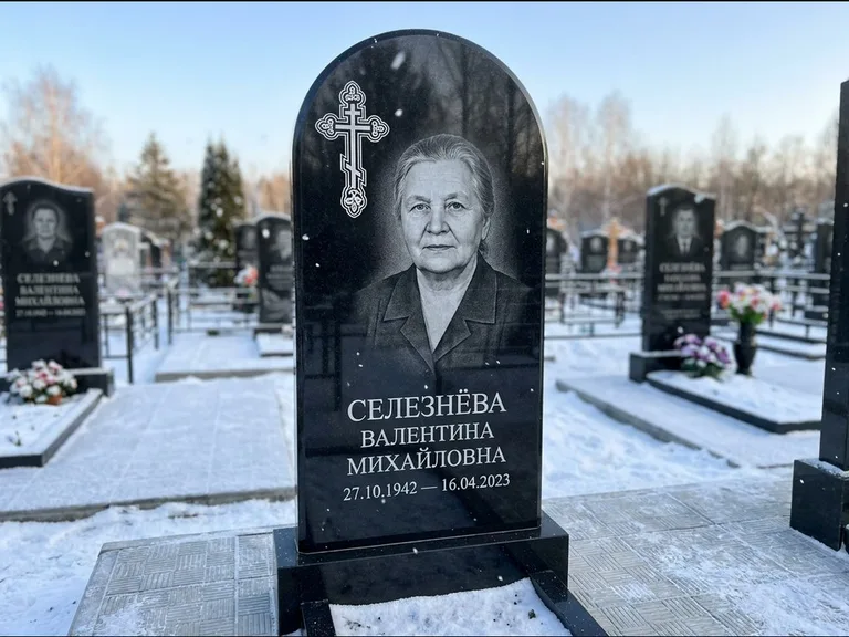 Памятник из чёрного гранита — массивная стела с крестом в лучах с крестом в лучах, работа «Одинцова» в Якутске