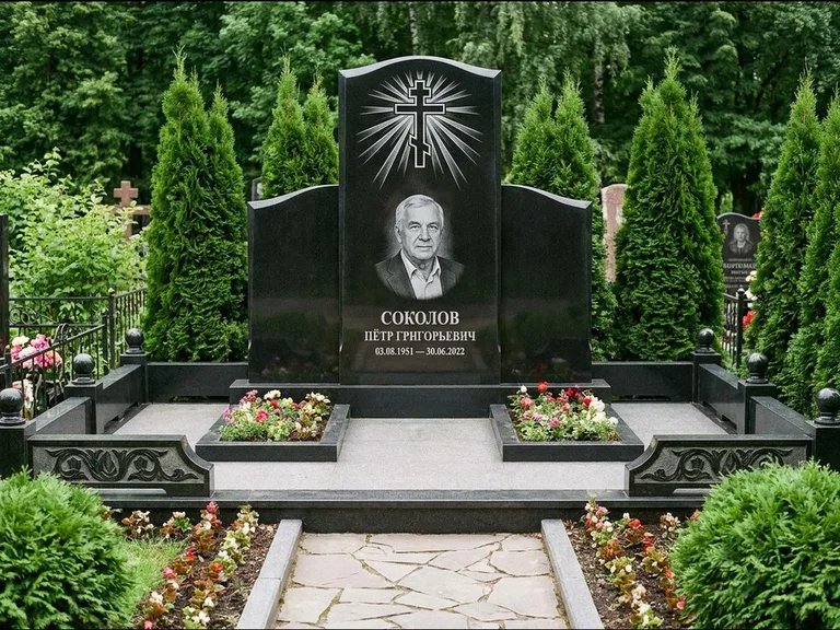 Памятник из чёрного гранита — низкая стела с крестом сбоку с золочёным крестом, работа «Верещагин» в Якутске