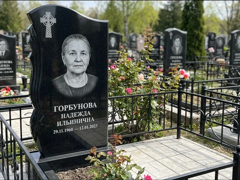 Памятник из чёрного гранита — высокий обелиск с кельтским крестом, работа «Одинцова» в Якутске