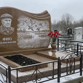 Гранитный памятник охотнику в виде скалы со сценой охоты